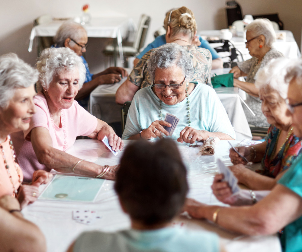 group of senior women playing cards in the community room
