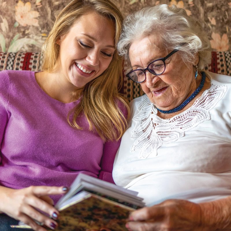 Employee looking at a photo album with a resident