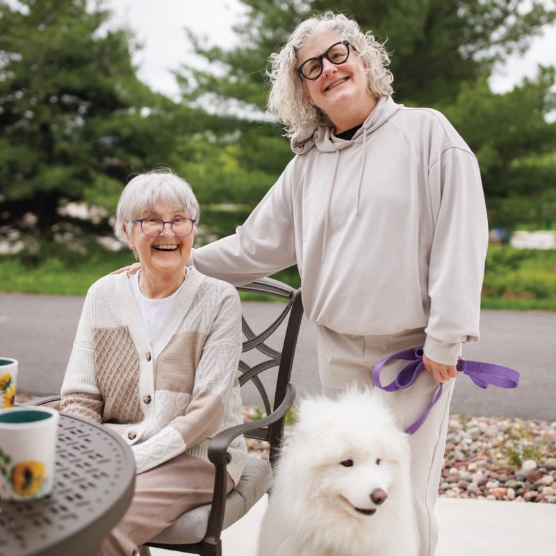 Residents with their dog An assisted living couple with their big white dog on the patio