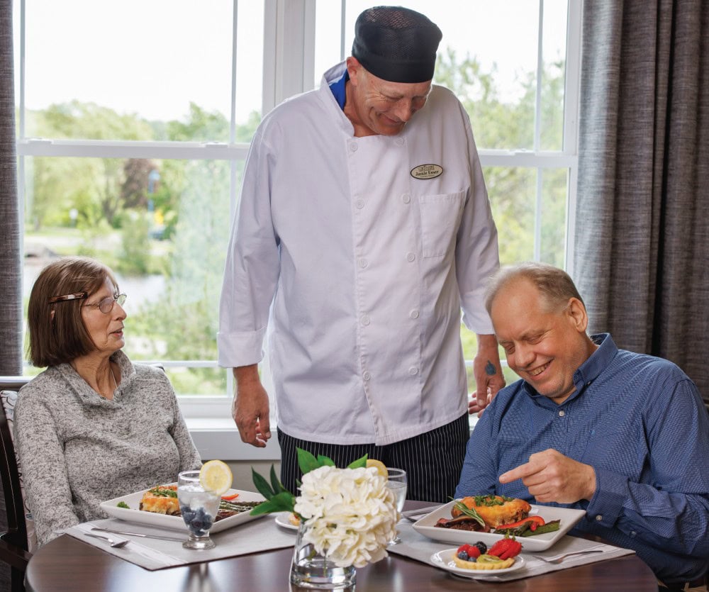 Couple Dining Chef presenting meal to a couple in the assisted living dining room