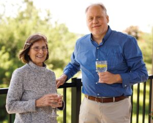 Senior woman and her husband enjoying resident life standing on their Assisted Living Balcony